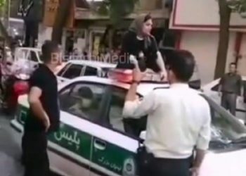 ماجرای نشستن یک زن روی سقف ماشین پلیس